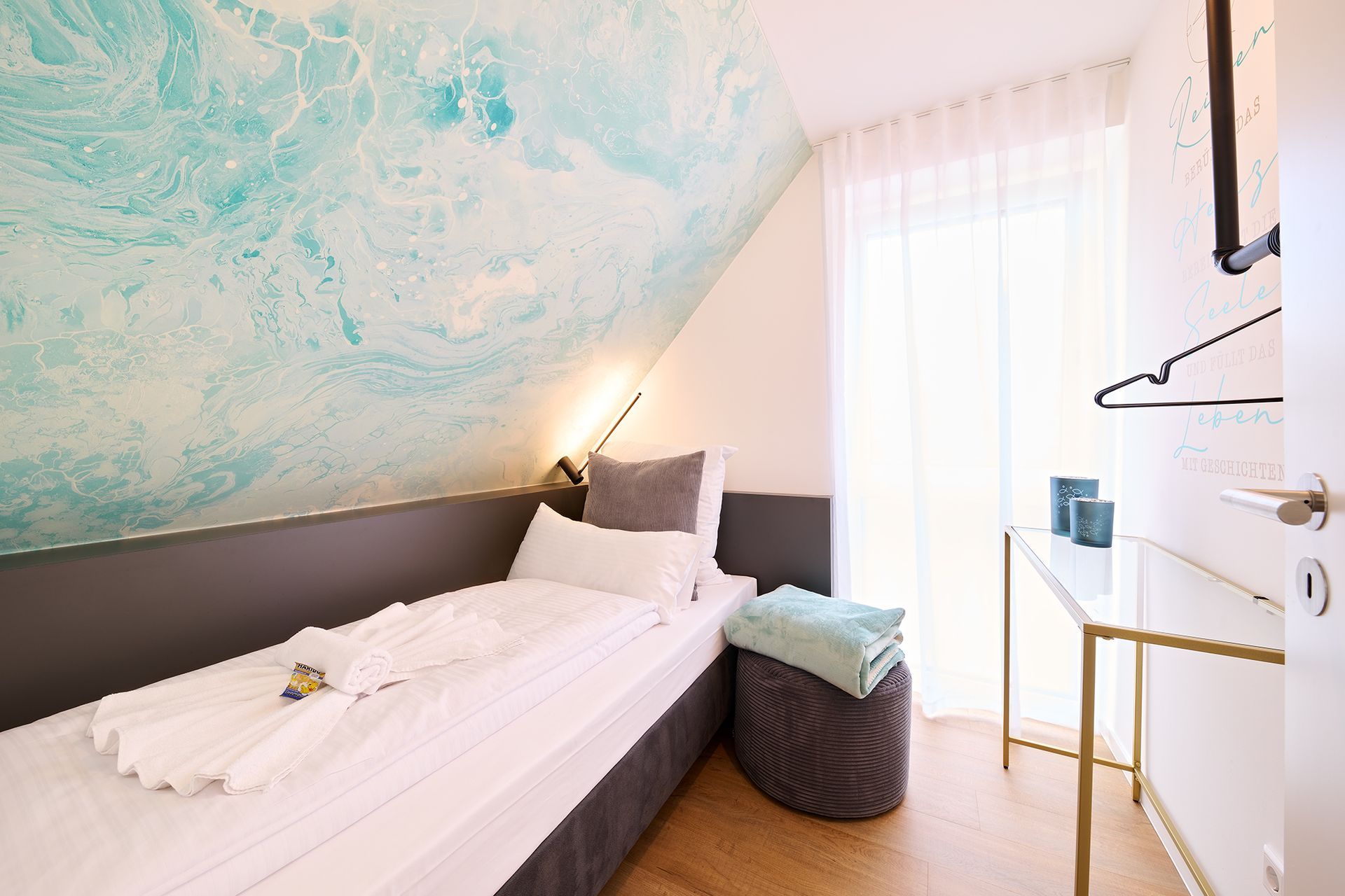 Ein Schlafzimmer mit einem Einzelbett, einem Schreibtisch und einem Fenster.