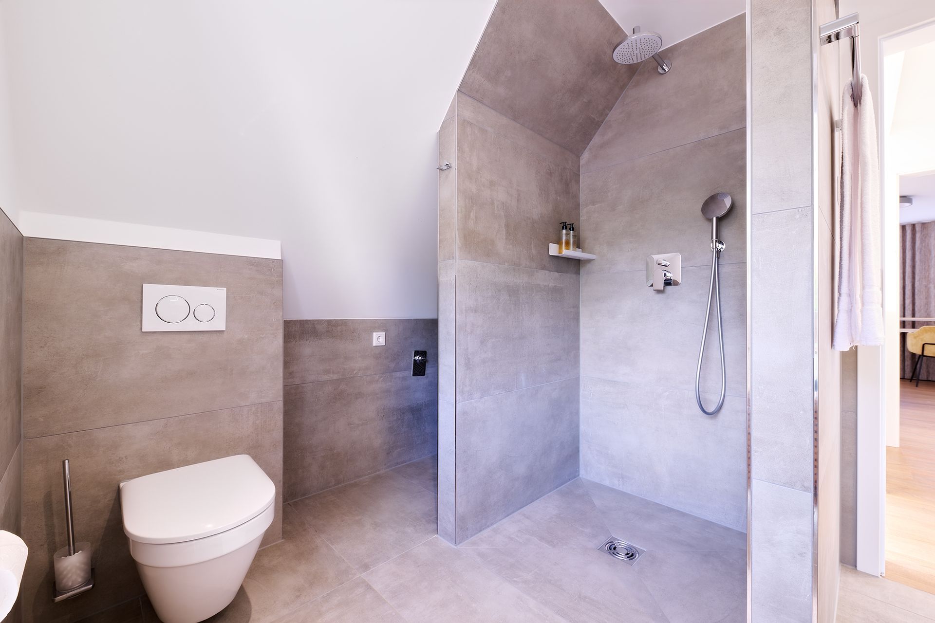 Ein Badezimmer mit Toilette und ebenerdiger Dusche