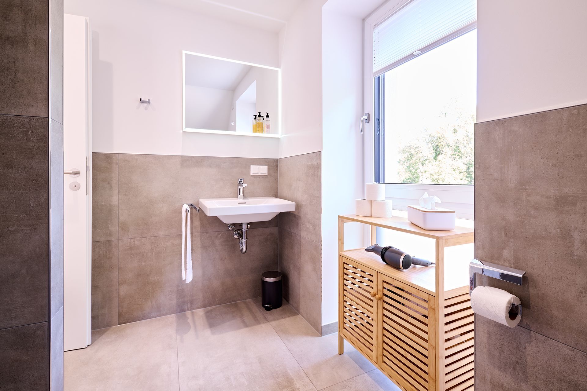 Ein Badezimmer mit Waschbecken, Spiegel und Fenster.