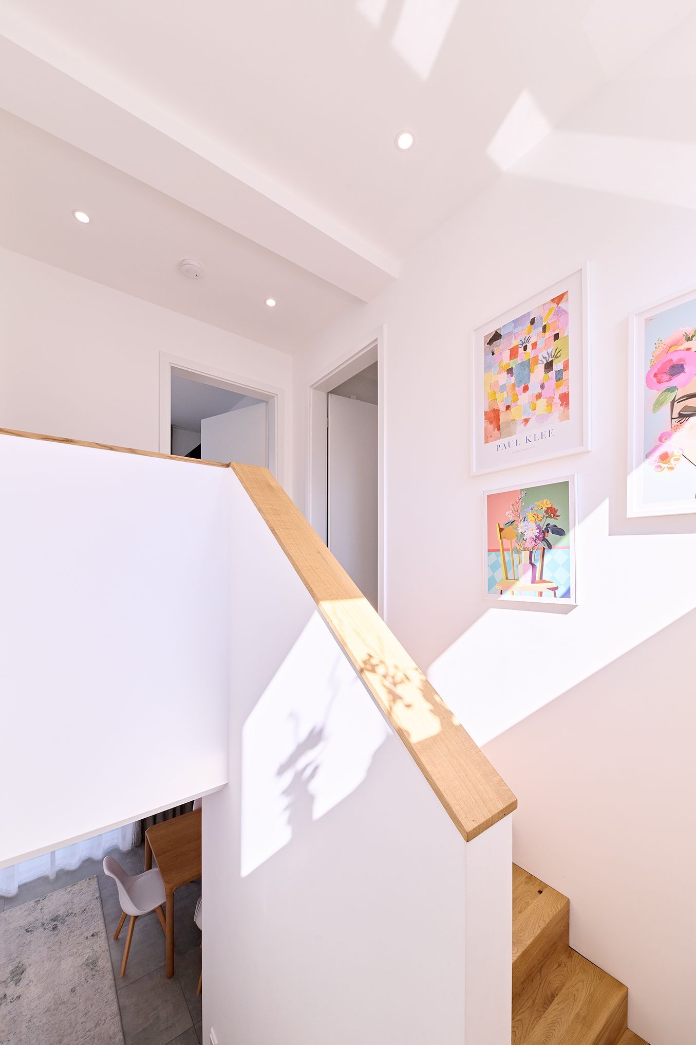 Eine Treppe mit Holzgeländer und Gemälden an der Wand