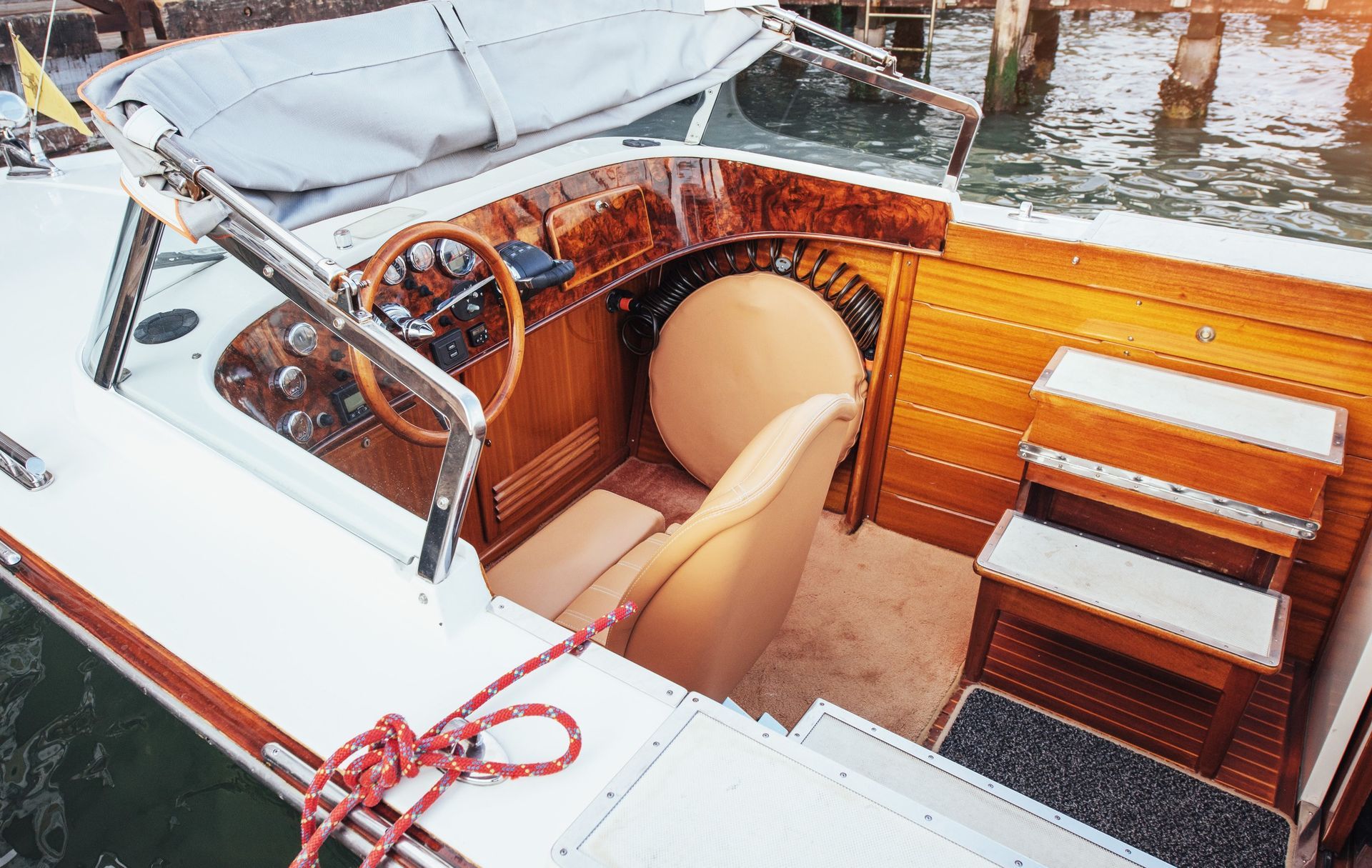 El interior de un barco con un volante de madera.