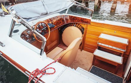 El interior de un barco con un volante de madera.