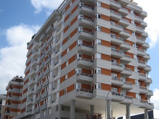 Un edificio alto con muchos balcones y ventanas.