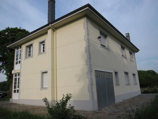 Una casa grande de color blanco con garaje y chimenea.