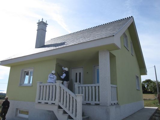 Una casa amarilla con un porche blanco y escaleras.