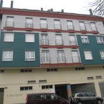 Un edificio grande con muchas ventanas y una camioneta estacionada frente a él.