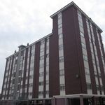 Un gran edificio de ladrillo con muchas ventanas en un día nublado.