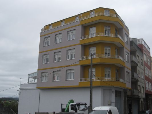 Una camioneta blanca está estacionada frente a un gran edificio.
