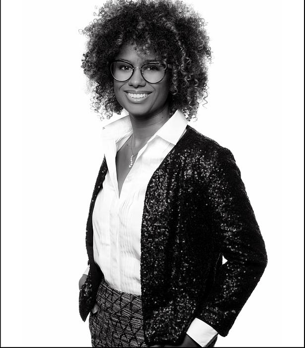 Photo en noir et blanc d'une d'une jeune femme souriante avec des lunettes