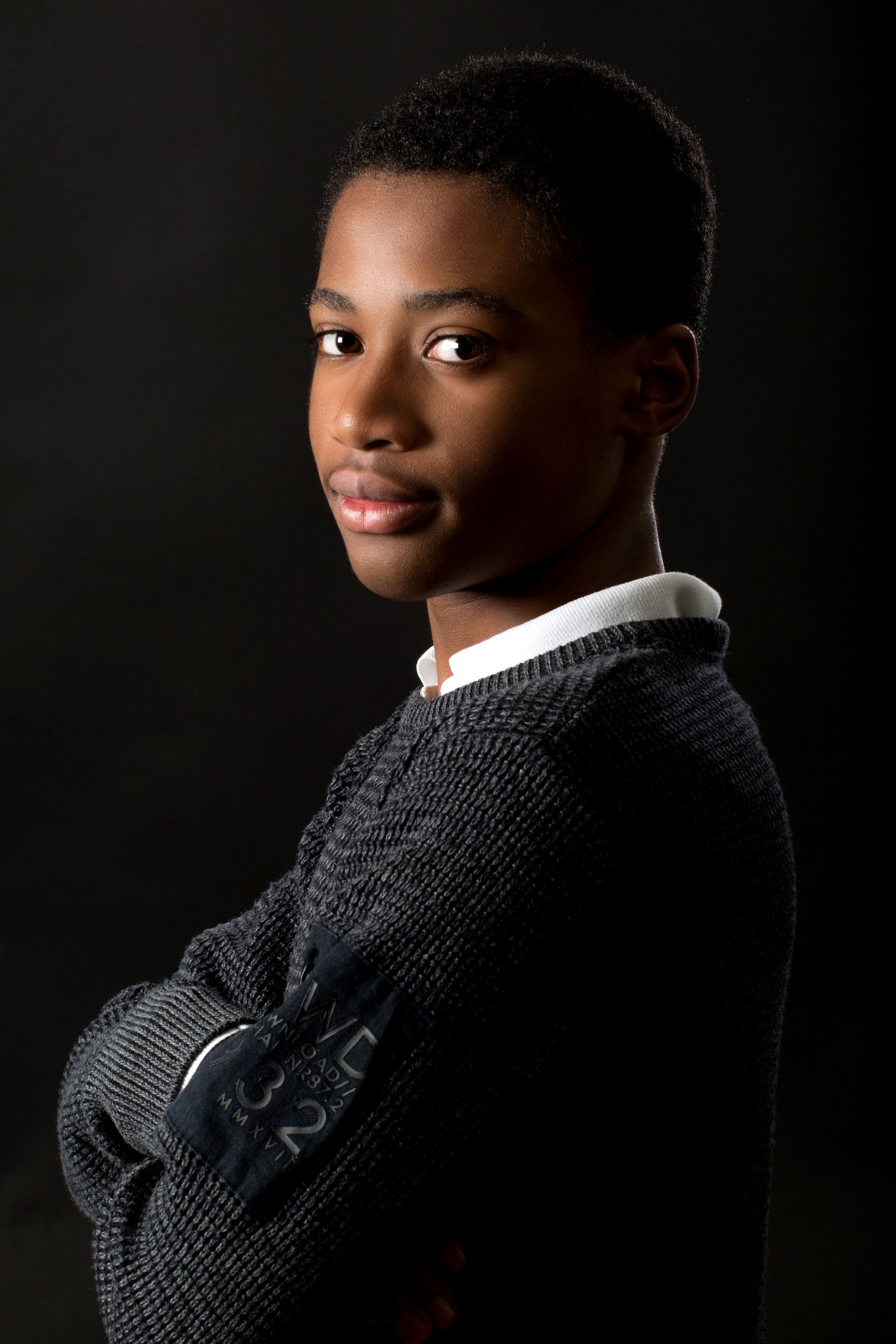 Photo trois quarts d'un jeune garçon avec les bras croisés