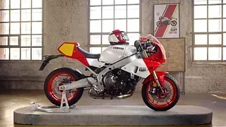 Una motocicleta roja y blanca está expuesta en una habitación.