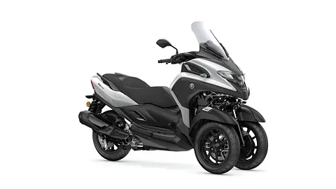 Un scooter blanco y negro con tres ruedas sobre un fondo blanco.