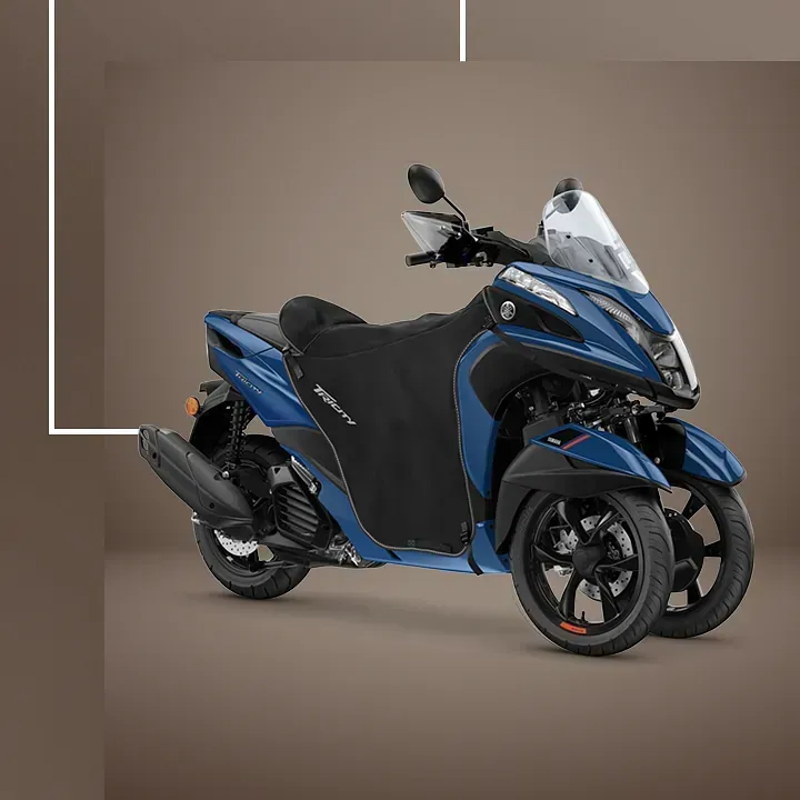 Un scooter azul y negro está estacionado sobre un fondo marrón.