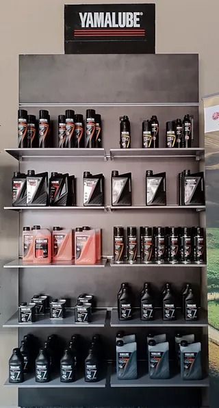 Una exhibición de aceites de yamalube en los estantes de una tienda.