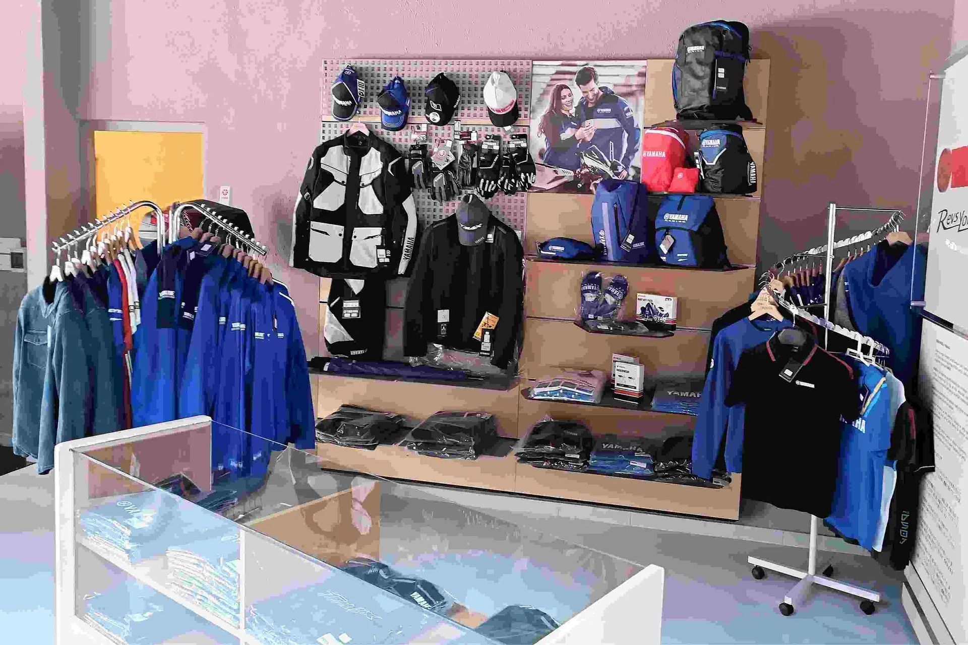 Una tienda llena de mucha ropa azul y mochilas.