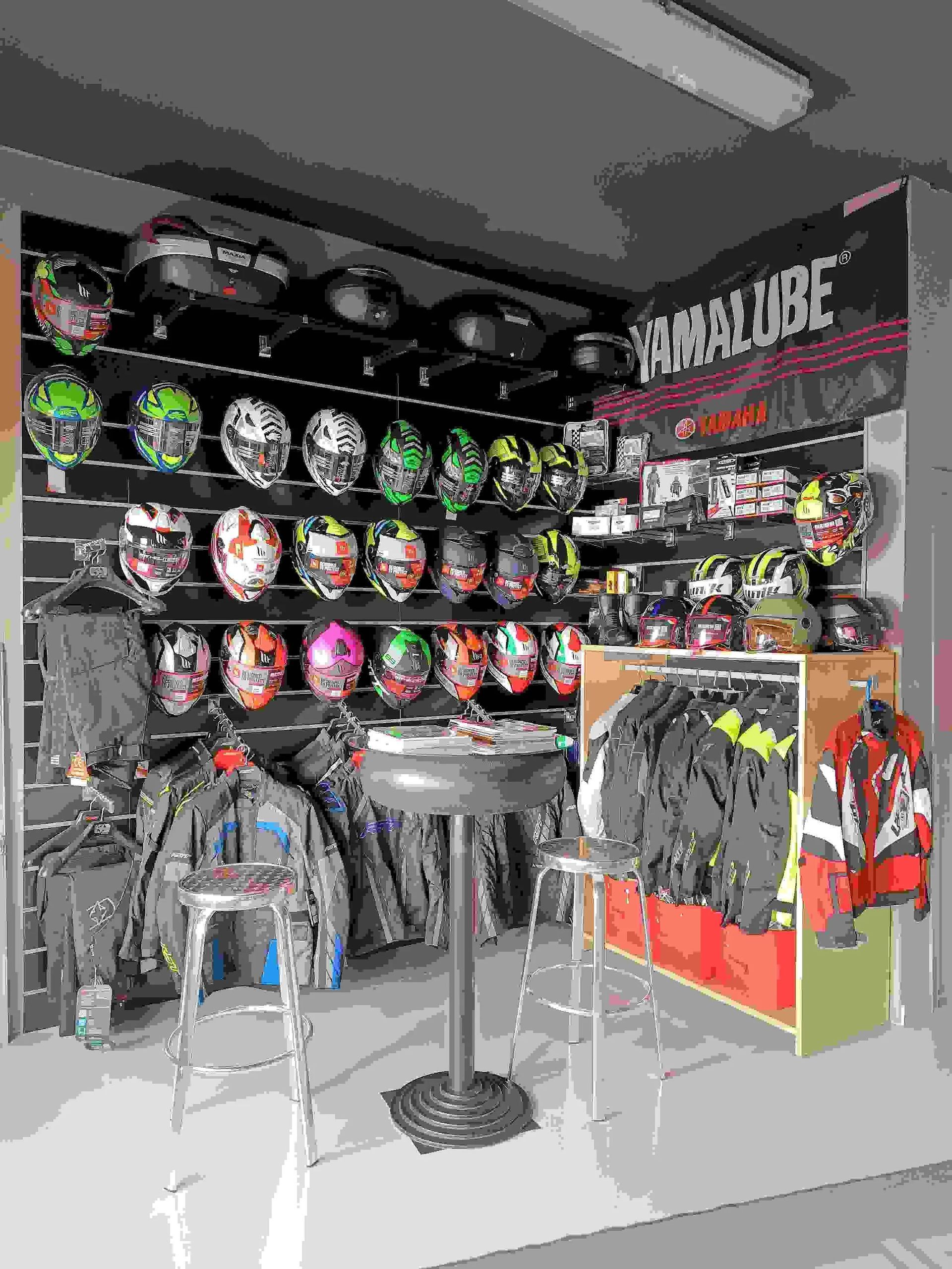 Una tienda de cascos de motocicleta con una mesa y sillas.