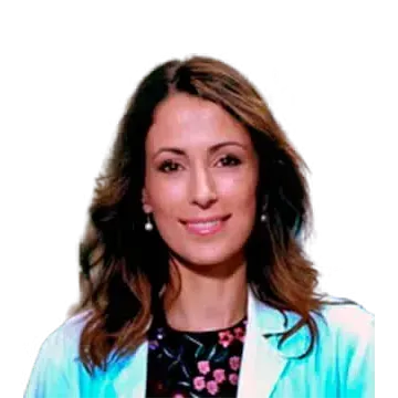 Mujer de cabello castaño con una bata de laboratorio azul claro sonriendo y con un top floral.