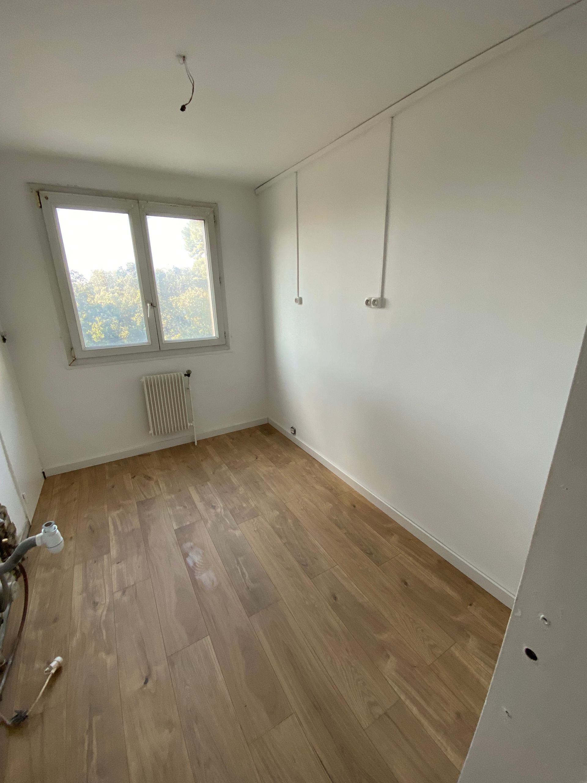 Pièce rénovée avec murs peints et pose de parquet