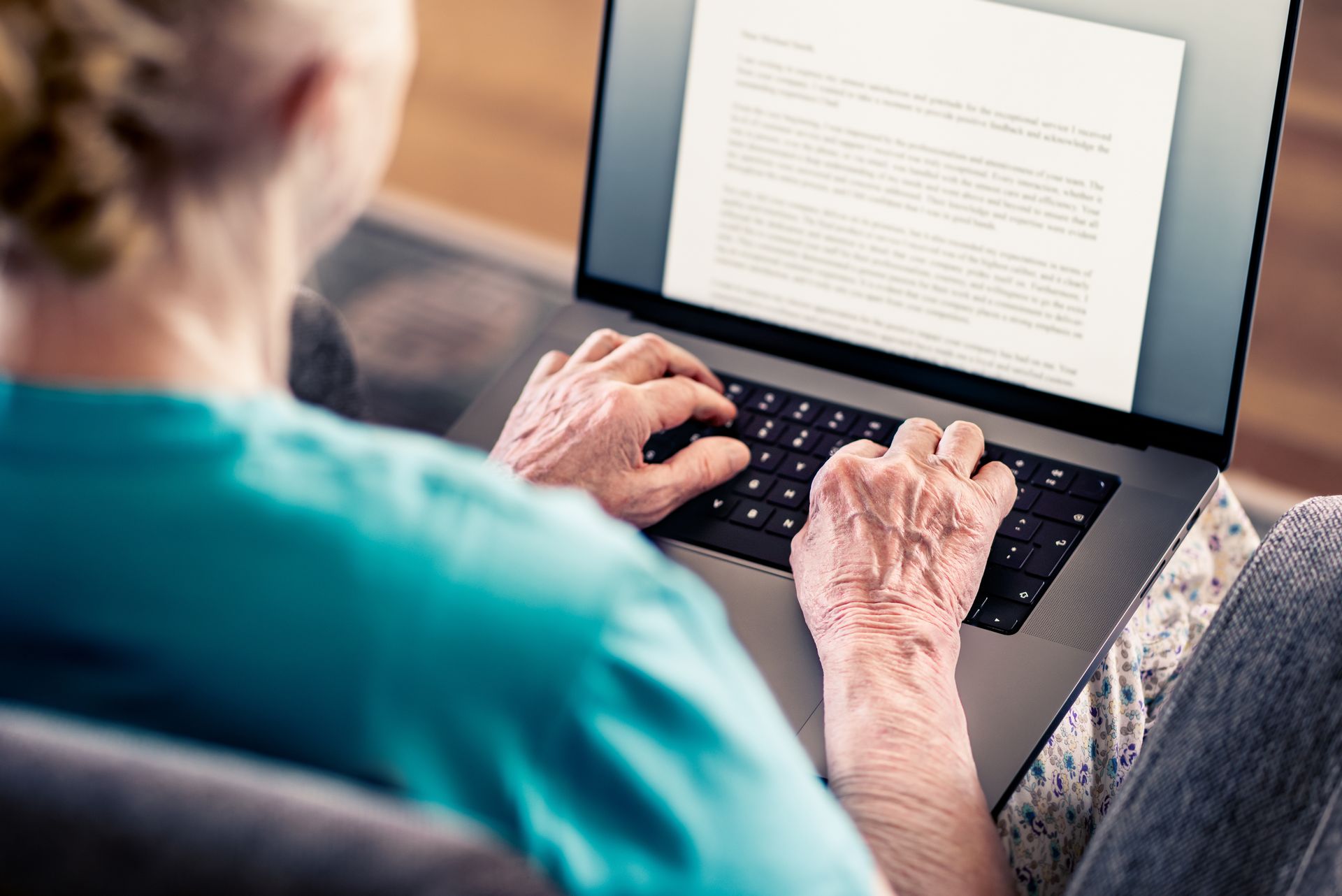 Une personne âgée qui rédige un document sur un logiciel de traitement de texte