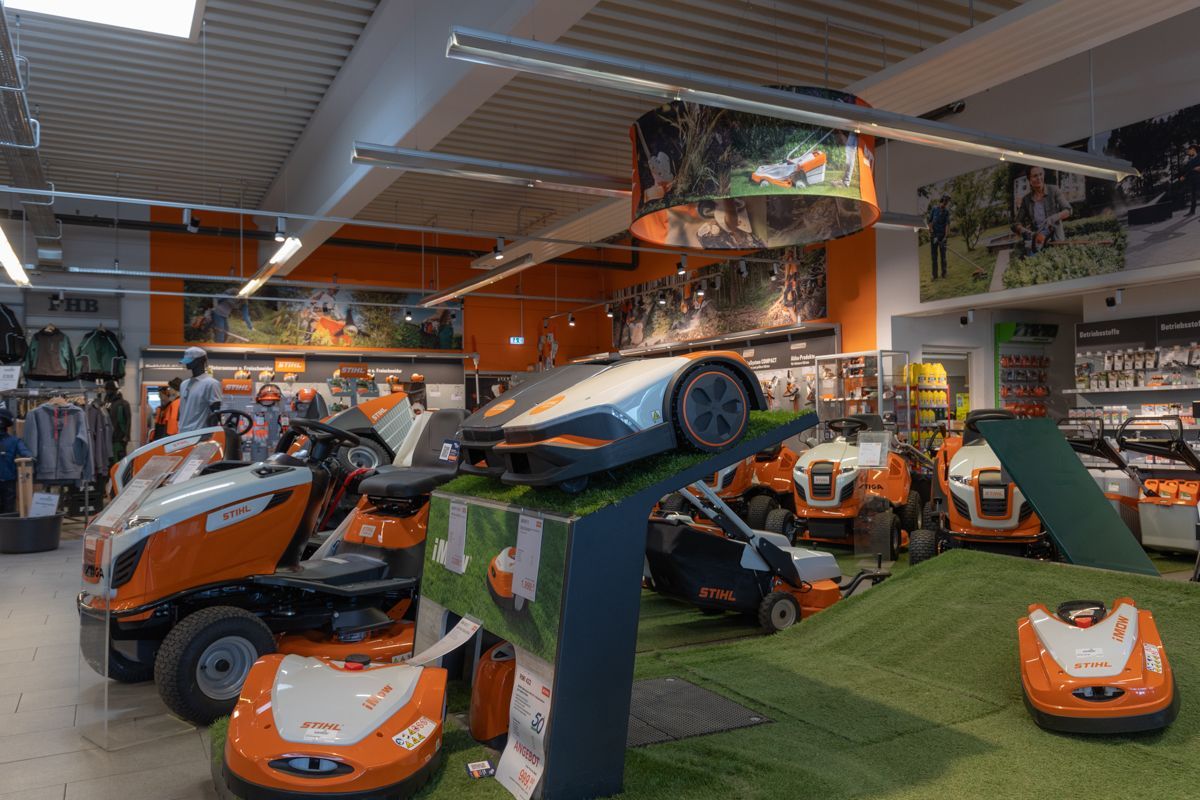 Eine Reihe Rasenmäher in einem Geschäft.