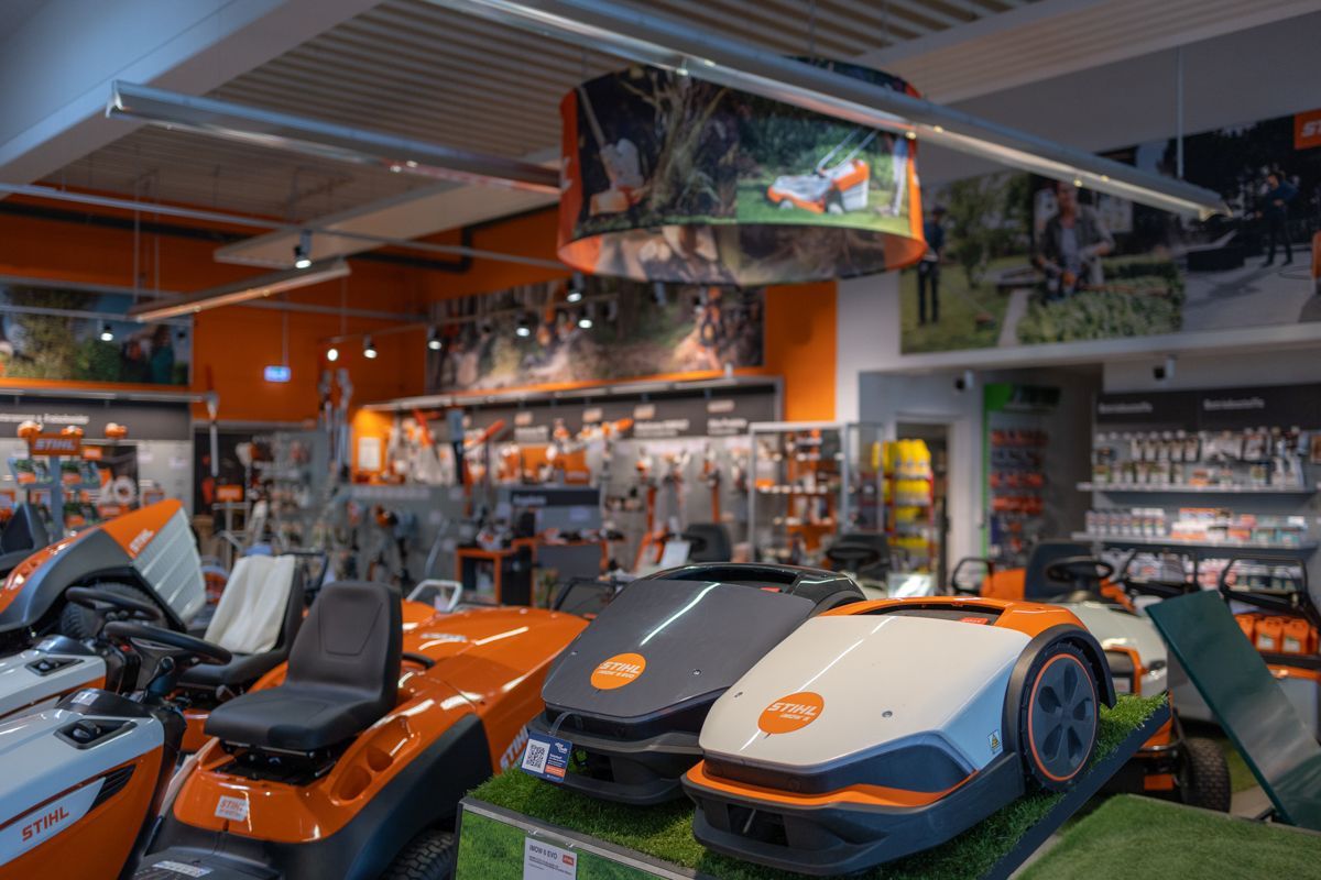 In einem Geschäft steht eine Reihe von Rasenmähern ausgestellt.