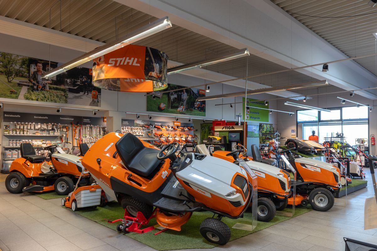 In einem Geschäft steht eine Reihe von Rasenmähern ausgestellt.