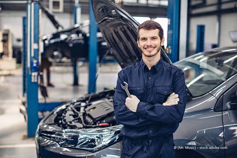 Automechaniker vor Pkw mit offener Kühlerhaube