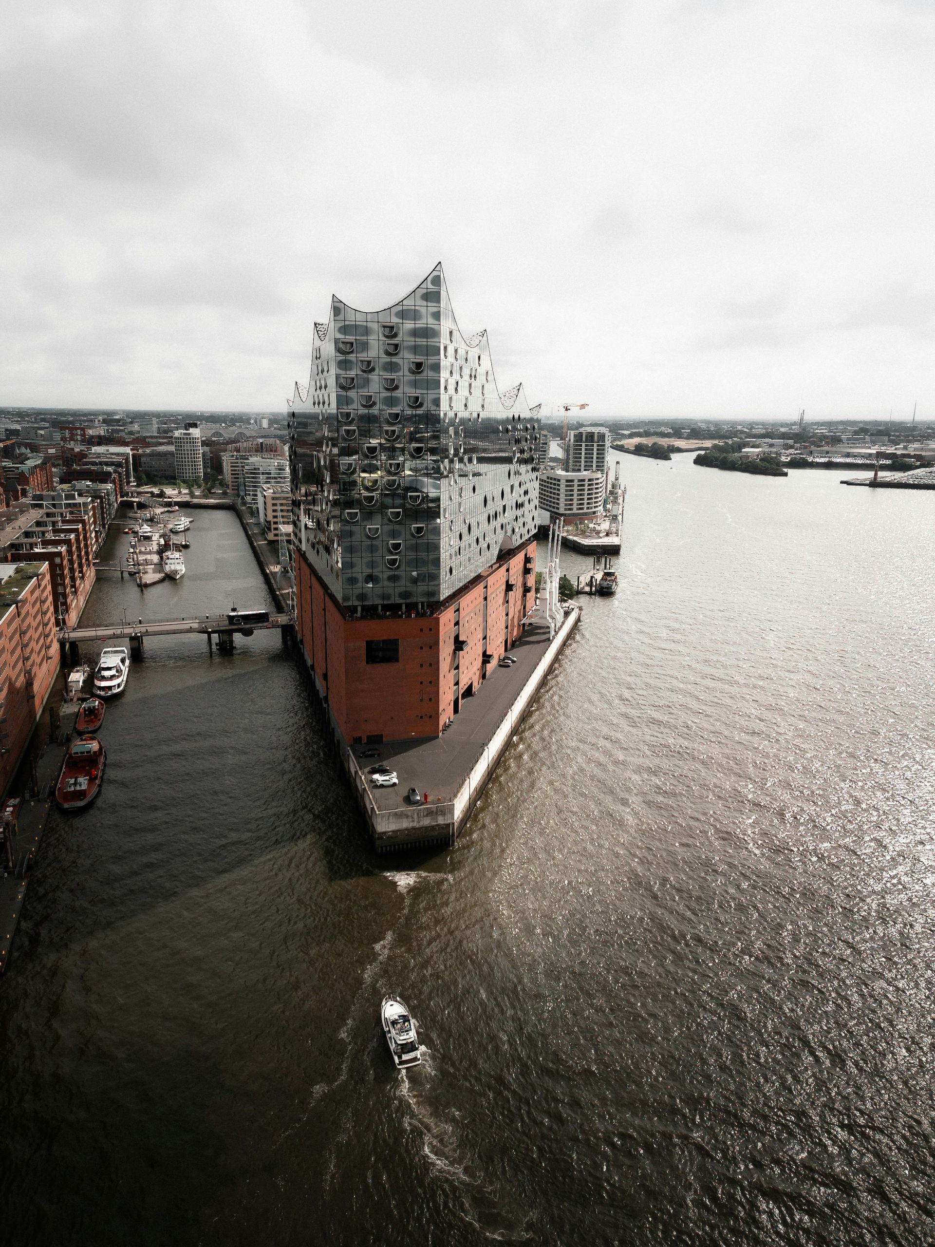 An aerial view of a large body of water with a large building in the background.