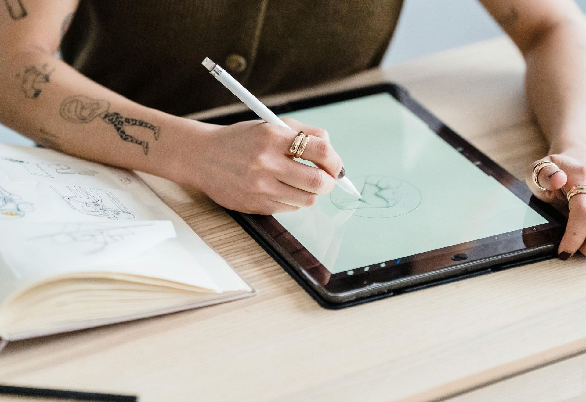 A woman is drawing on a tablet with a pen.