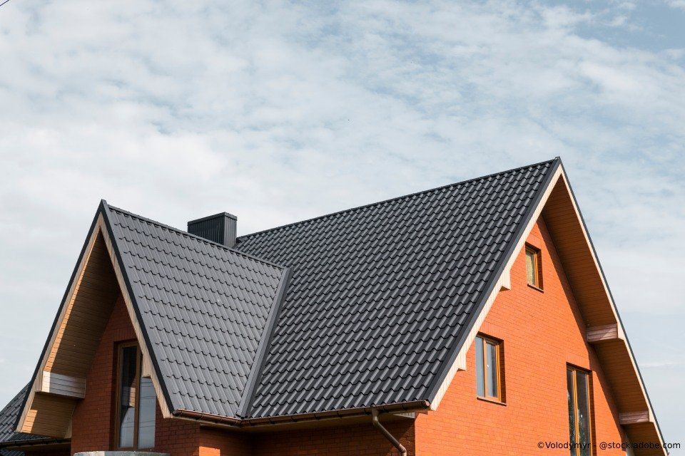 Schwarzes Dach der Firma Busch Ramona auf einem orangefarbenem Haus