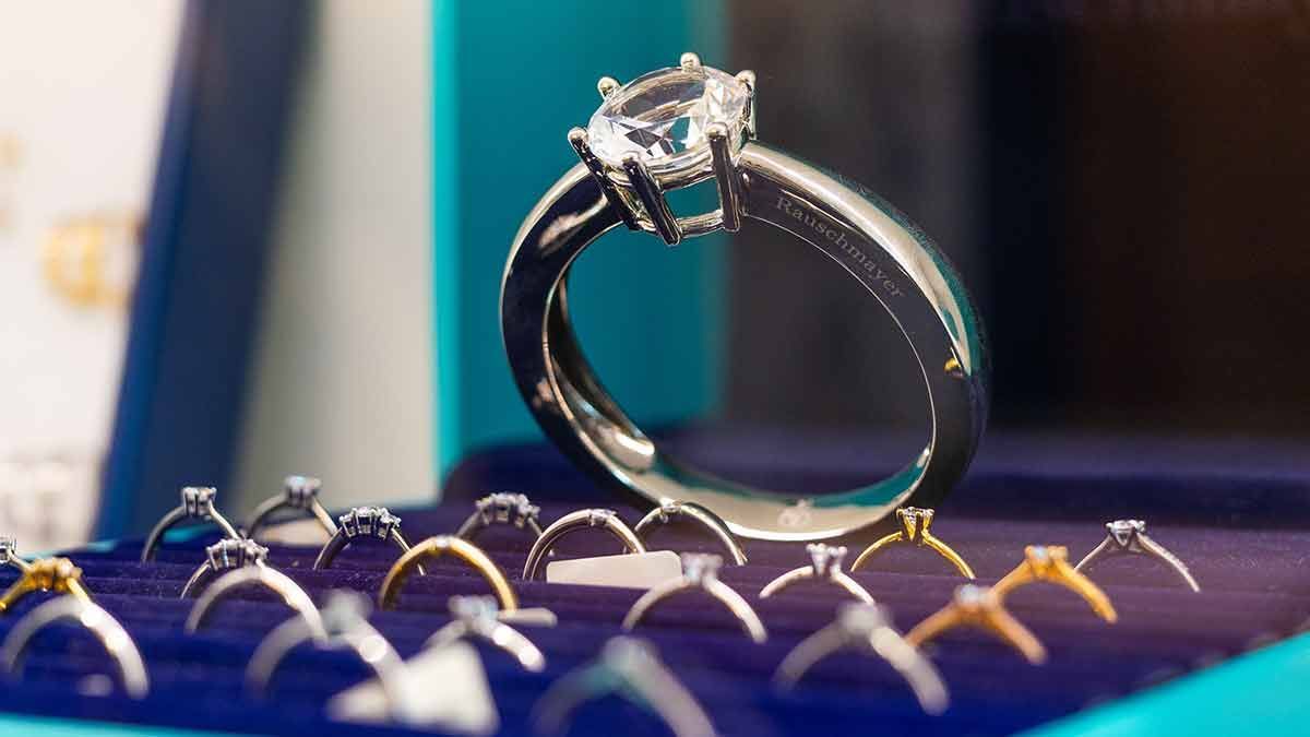 Ein Diamantring liegt auf einem Stapel anderer Ringe.