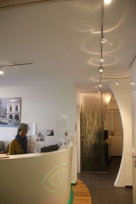 Eine Frau sitzt am Praxistresen. Foto von der Gruppenpraxis Dr. Braun & Fränkl