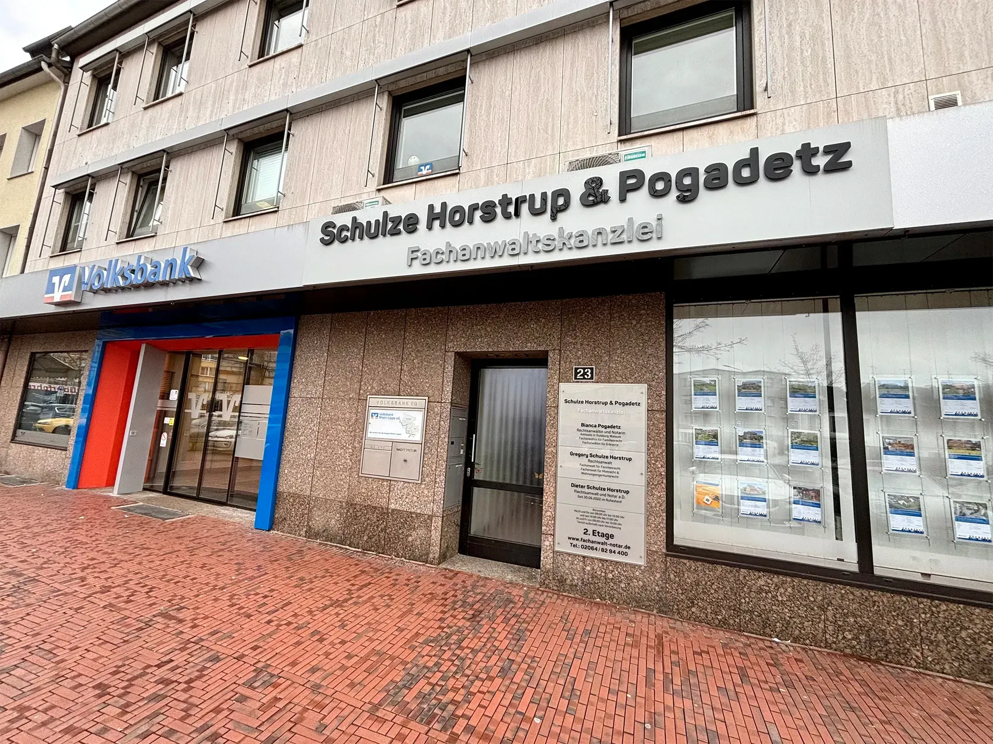 Ein Gebäude mit vielen Fenstern und einem Schild mit der Aufschrift „Schütze Horstrup & Pogodetz“.