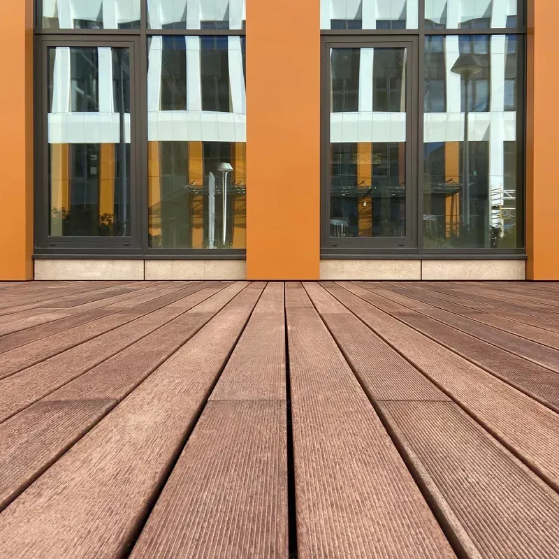 Holzterrasse mit modernen Glastüren und orangefarbenen Wandpaneelen