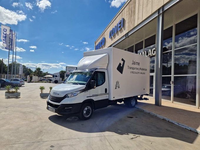 Dos camiones volquete Volvo blancos estacionados en un aparcamiento bajo un cielo nublado.