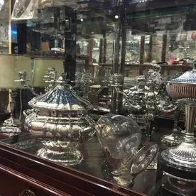 Una vitrina llena de objetos de plata y cristal.