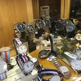 Un montón de relojes están sobre una mesa en una tienda.