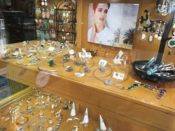 Una exhibición de joyas en una tienda con una imagen de una mujer en el fondo.