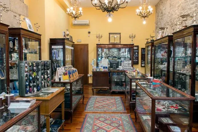 Una tienda llena de vitrinas y una lámpara de araña.