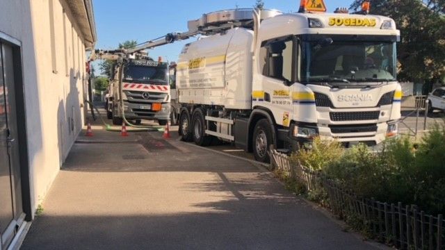 Camions de Sogedas garés à proximité d'un lieu d'intervention.