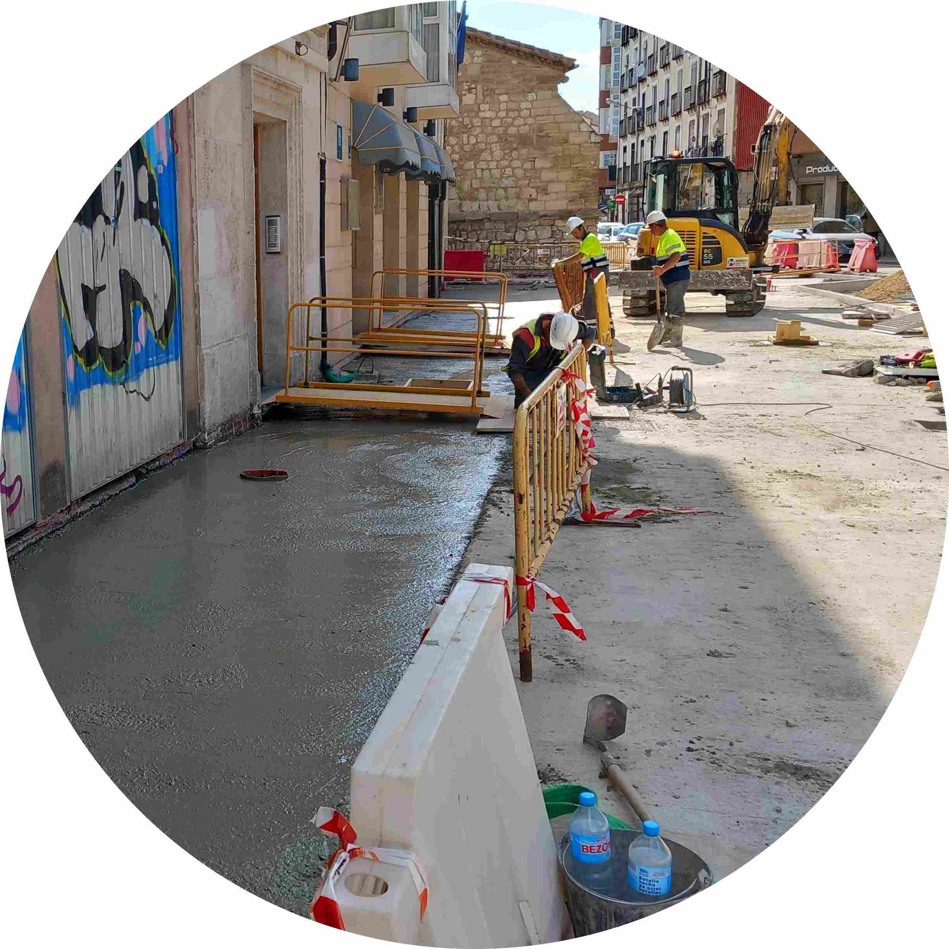 Los trabajadores de la construcción están trabajando en una acera en círculo.