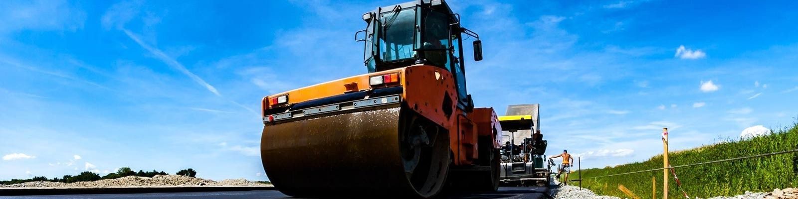 Un rodillo compactador está apisonando asfalto en una carretera.