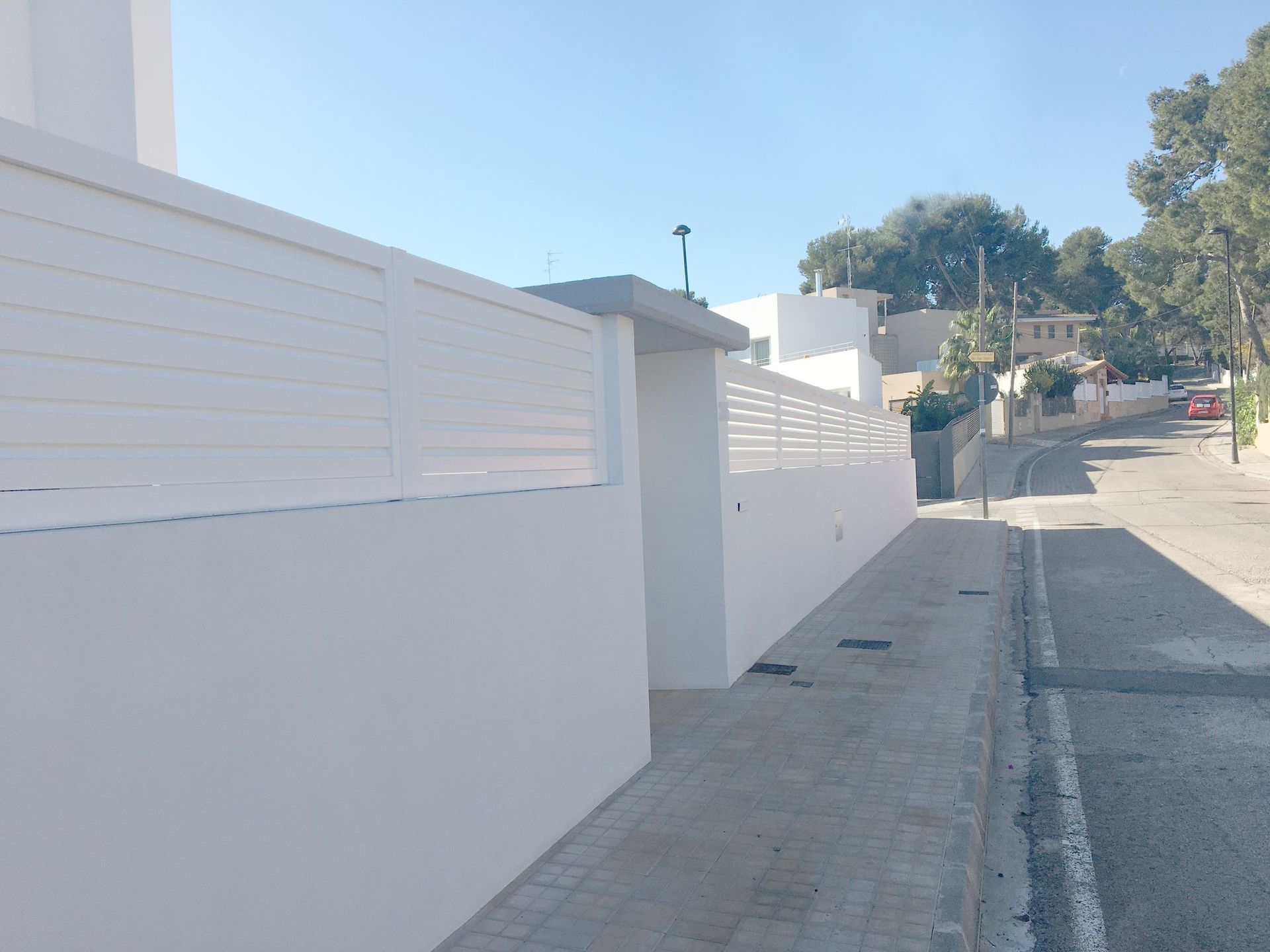 Una valla blanca al costado de una carretera