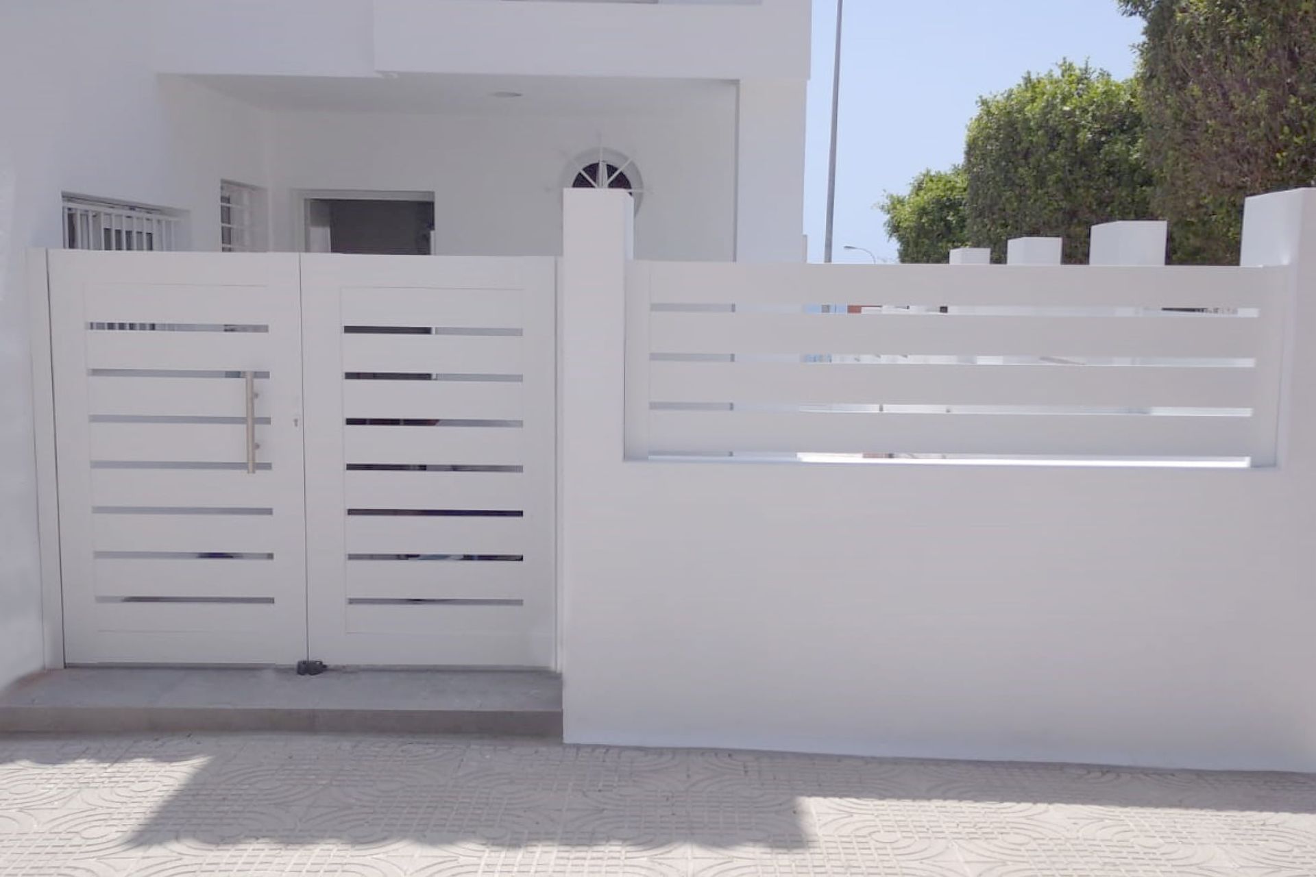 Una casa blanca con una valla blanca delante