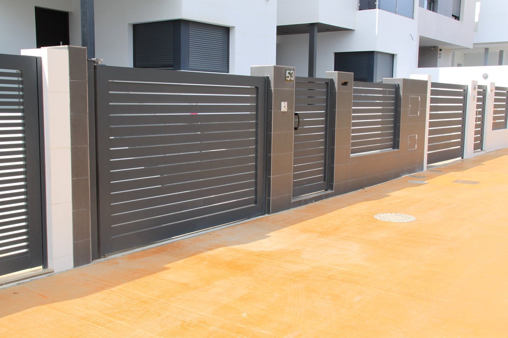 Una valla con una puerta delante de un edificio.