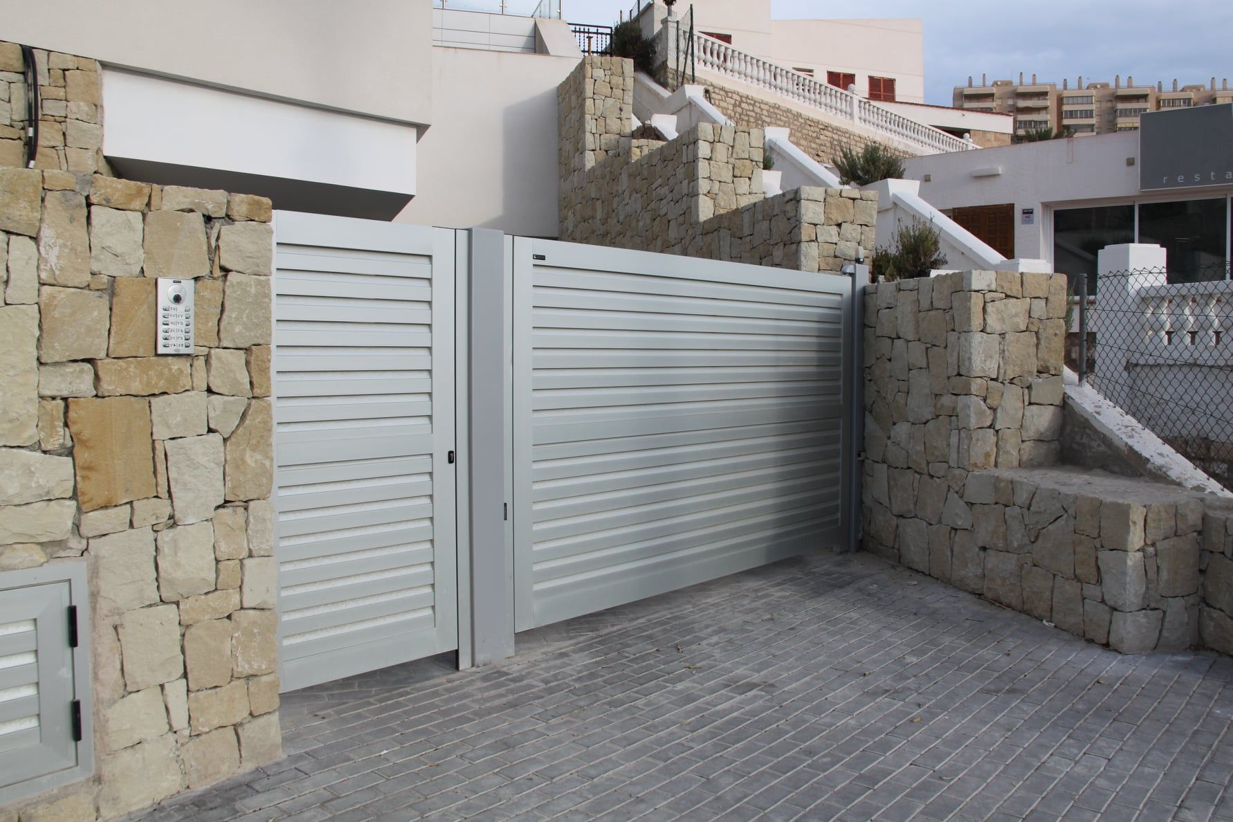 Un muro de piedra con una puerta corrediza delante.