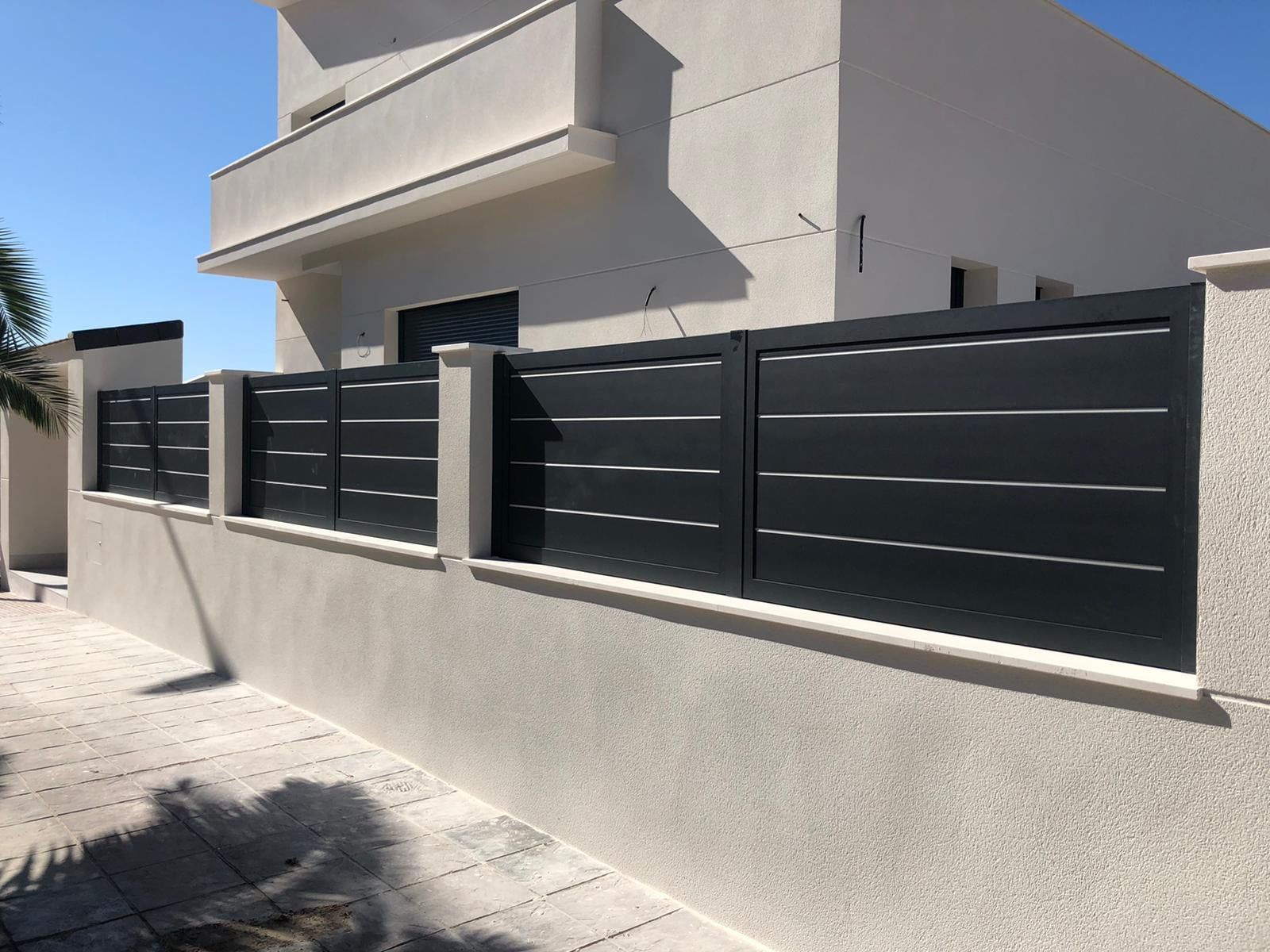 Una casa blanca con una valla negra delante