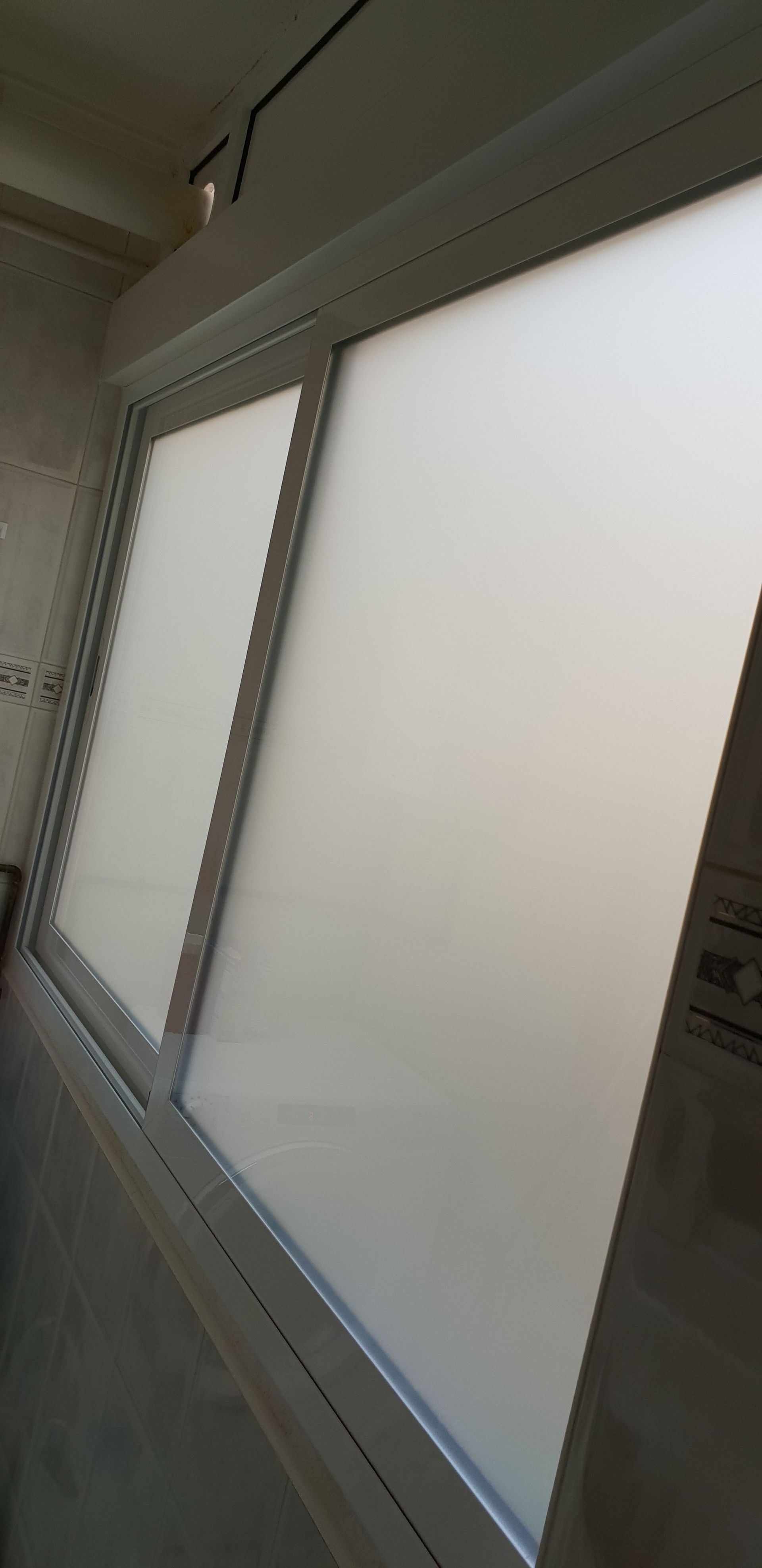 Un primer plano de una ventana con vidrio esmerilado en una habitación.