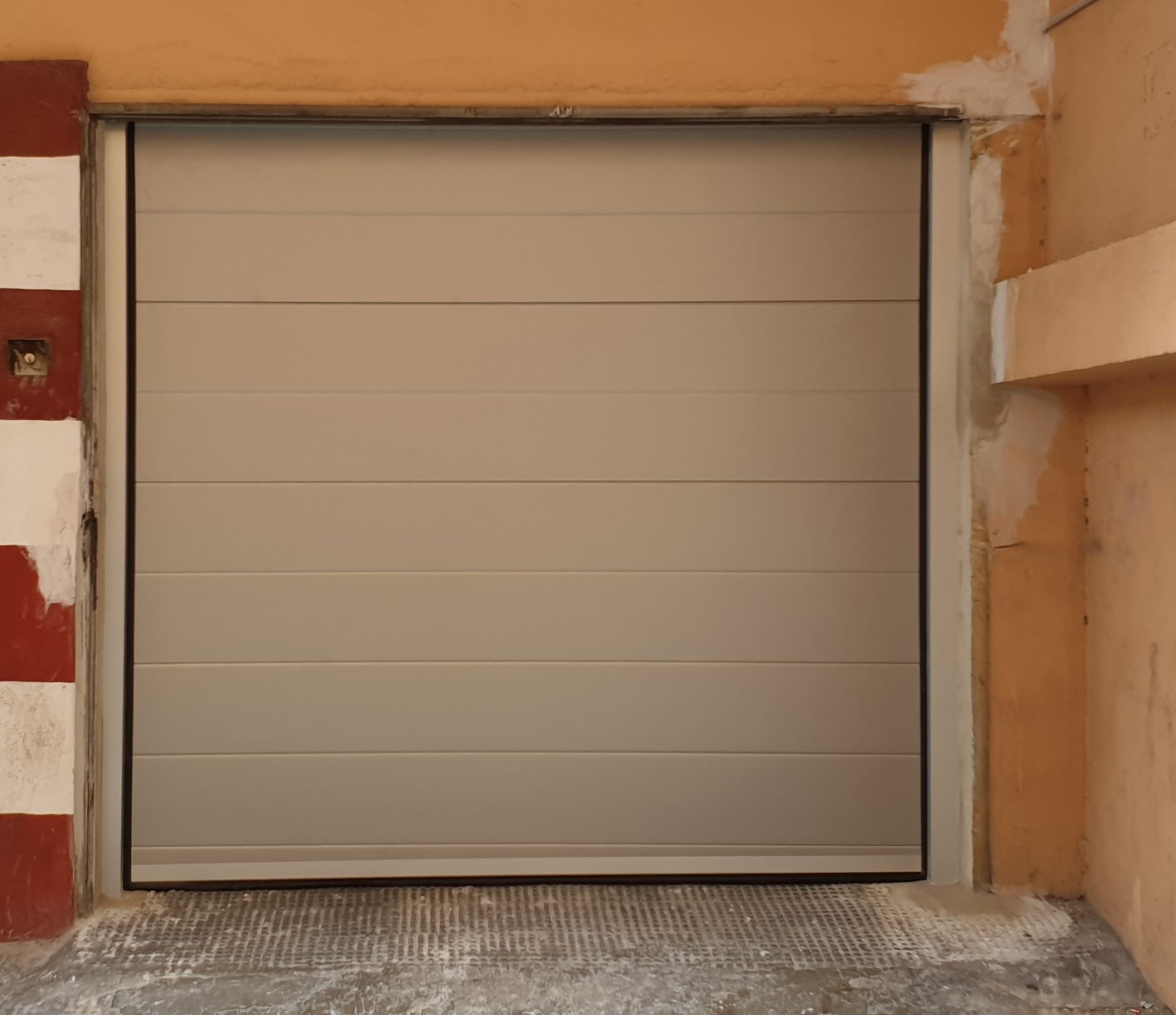 Una puerta de garaje blanca está abierta en un edificio.