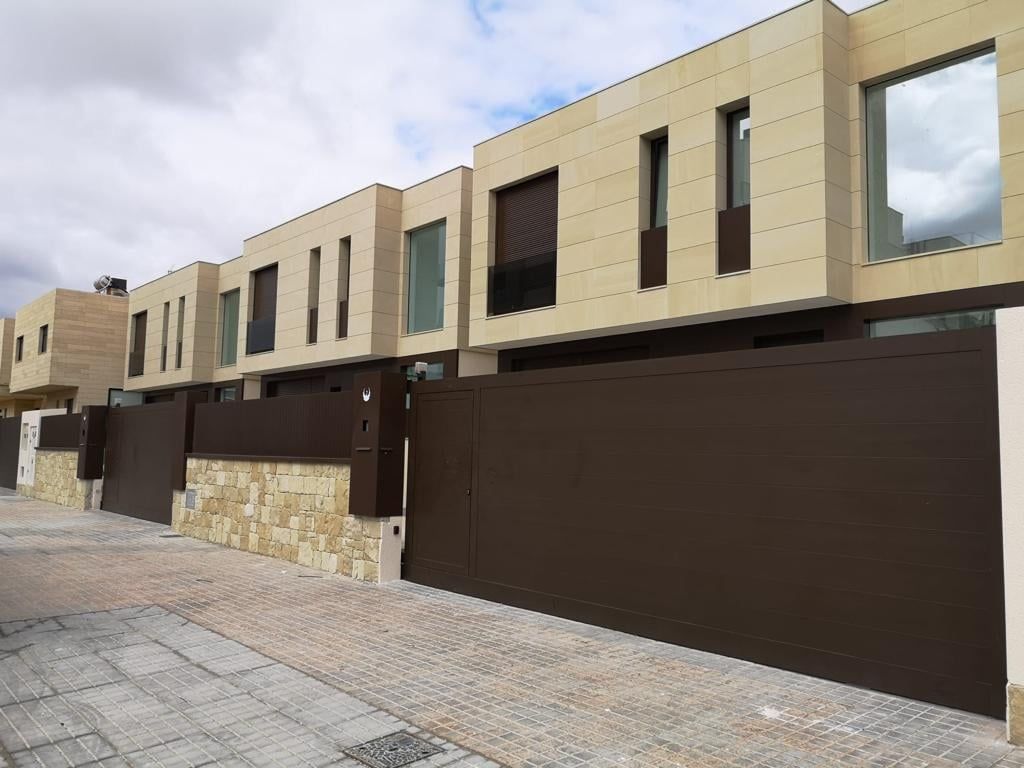 Una hilera de casas con una valla marrón delante de ellas.